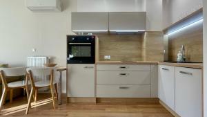 a kitchen with white cabinets and a table with chairs at Opera Park 23 by RENT4YOU in Olsztyn
