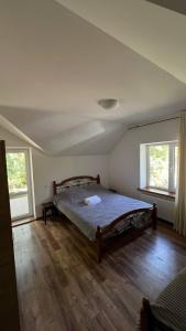 1 dormitorio con 1 cama en una habitación con suelo de madera en Vila Poiana Vadului, en Vadul lui Vodă