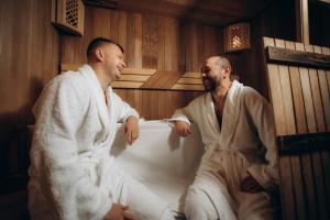 Dos hombres están sentados en una bañera. en Vila Poiana Vadului, en Vadul lui Vodă