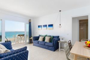 a living room with a blue couch and a table at YourHouse Ocean in Can Picafort
