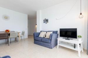 sala de estar con sofá, TV y mesa en YourHouse Ocean, en Can Picafort