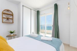 a bedroom with a bed and a large window at YourHouse Ocean in Can Picafort