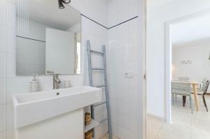 a white bathroom with a sink and a mirror at YourHouse Ocean in Can Picafort +27 photos