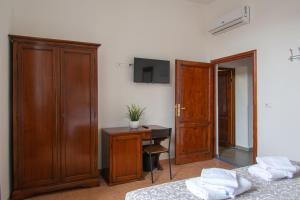 a bedroom with a desk and a tv on a wall at Paraiso in Florence