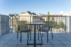 2 sillas y una mesa en el balcón en numa I Terra Apartments, en Viena