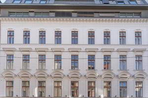 eine Fassade eines weißen Gebäudes mit Fenstern in der Unterkunft Numa Vienna Terra in Wien