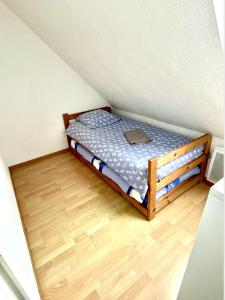 een klein bed in een kamer met een houten vloer bij Jolie petite maison à 500m de la plage d'Erdeven in Erdeven