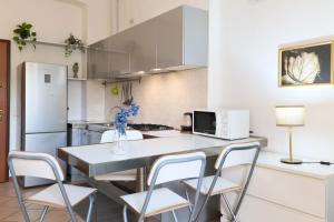 uma cozinha com uma mesa com cadeiras e um frigorífico em PrimoPiano - Scalvini em Milão