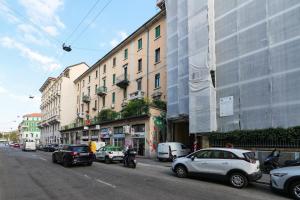 una strada cittadina con auto parcheggiate sul lato della strada di PrimoPiano - Scalvini a Milano