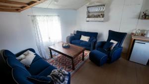 un soggiorno con divani blu e un tavolo di Real fisherman's cabins in Ballstad, Lofoten - nr. 11, Johnbua a Ballstad