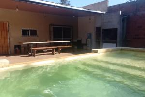 uma piscina com mesa de pingue-pongue ao lado de uma casa em Casa Laurel em Puerto Iguazú