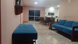 uma sala de estar com um sofá azul e uma mesa em Casa Laurel em Puerto Iguazú