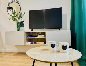 two coffee mugs on a table in a living room at Opera Park 128 by RENT4YOU in Olsztyn