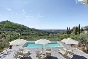 a swimming pool with chairs and umbrellas at Villa Cielo Blu - Homelike Villas in Montecatini Terme