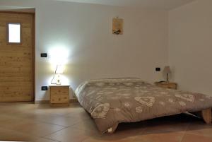 una camera con letto, lampada e porta di Casa Girod - Il Rustico a Issime