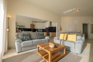 uma sala de estar com dois sofás e uma mesa de centro em Fábrica da Ribeira 54 by Destination Algarve em Lagos