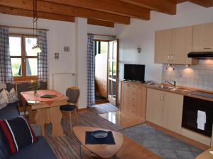 Ferienhof Schauer في باد إندورف: مطبخ وغرفة معيشة مع طاولة وأريكة