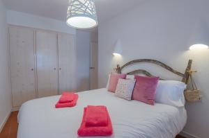 een slaapkamer met een wit bed met rode handdoeken erop bij La maison dans la calanque 1 mn à pied de la plage d'ALCAUFAR 