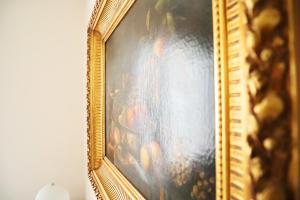 a picture of a painting in a gold frame at Repubblica Elegant Milan House in Milan