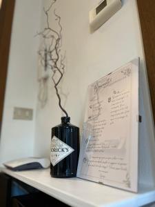 un jarrón negro sentado en una mesa junto a un libro en Appartamento Ai Palasi, en Vittorio Veneto