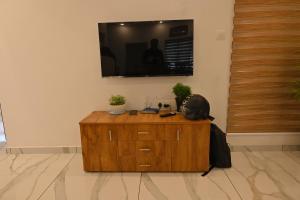 a wooden cabinet with a television on a wall at Holiday Villa - Your Second Home - Kothamangalam in Kotamangalam