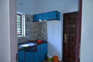 une cuisine bleue avec une armoire bleue et une fenêtre dans l'établissement Holiday Villa - Your Second Home - Kothamangalam, à Kotamangalam
