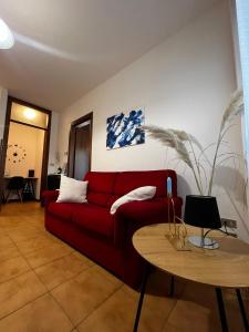 sala de estar con sofá rojo y mesa en Appartamento Ai Palasi, en Vittorio Veneto