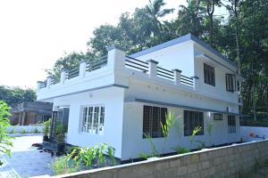 a white house with a fence at Holiday Villa - Your Second Home - Kothamangalam in Kotamangalam