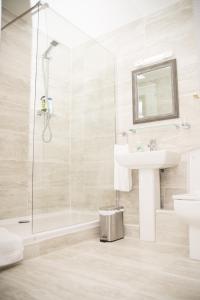 a white bathroom with a sink and a shower at Dublin Exchange Suites in Dublin +53 photos