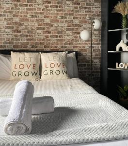 a bedroom with a white bed with a brick wall at Modern Studios Close To Hyde Park in London