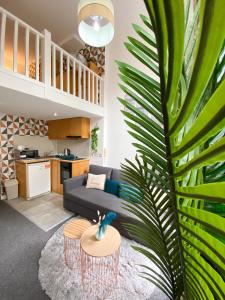 a living room with a couch and a palm tree at Modern Studios Close To Hyde Park in London +53 photos