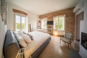 a bedroom with a large bed and a brick wall at Langhe Country House in Neive
