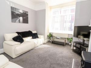 un soggiorno con divano bianco e TV di Lucys Retreat a Bridlington