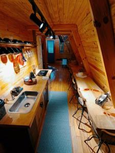 eine Küche in einer Hütte mit einem Waschbecken und Stühlen in der Unterkunft Chalés Recanto do Vale - GRALHA AZUL in Bom Jardim da Serra