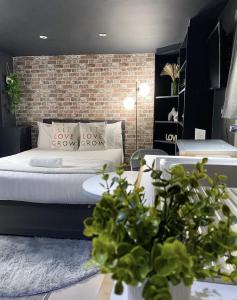 een slaapkamer met een bed en een bakstenen muur bij Modern Studios Close To Hyde Park in Londen
