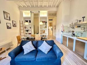 a living room with a blue couch and a kitchen at Near Ponte Vecchio: central luxury flat in Florence