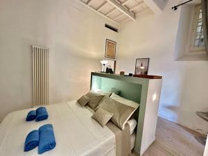 a bedroom with a bed with blue slippers on it at Near Ponte Vecchio: central luxury flat in Florence