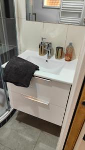 Un lavabo blanco con dos tazas. en Studio due cosy, en Choisy-le-Roi