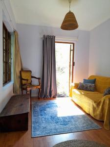 een woonkamer met een bank en een raam bij Bushman's Pillow in Sanddrif