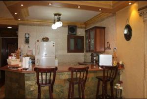 a kitchen with a counter with chairs and a refrigerator at شقه مفروشه مميزه in Cairo