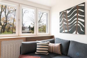 a living room with a couch and two windows at Baltic Breeze Apartment 3city Gdańsk by Noclegi Renters in Gdańsk +3 photos