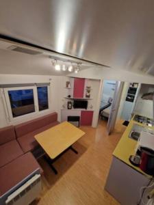 a living room with a couch and a table at Charmant mobilhome à 2 pas remontés ski Samoëns in Samoëns