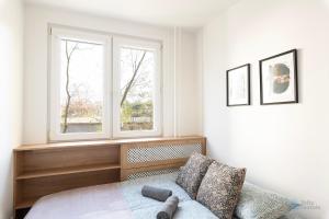 een slaapkamer met een bed en een raam bij Samba by 3City Rentals in Gdańsk