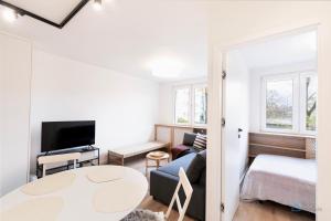 een woonkamer met een bank, een bed en een tafel bij Samba by 3City Rentals in Gdańsk