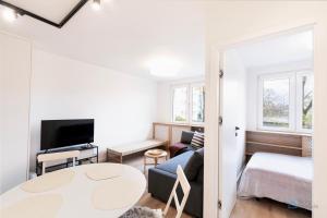 a living room with a couch and a bed and a table at Baltic Breeze Apartment 3city Gdańsk by Noclegi Renters in Gdańsk