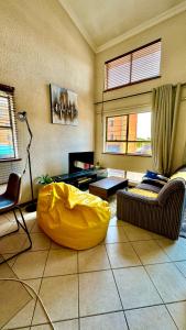 a living room with a yellow couch in the middle at Chic Urban Loft in Pretoria in Pretoria