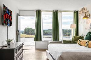 una camera d'albergo con un letto e una grande finestra di The Mallard Hotel & Suites a Copperhill