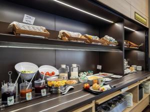 a buffet line with plates of food in a kitchen at B&B HOTEL Düsseldorf-Mitte in Düsseldorf