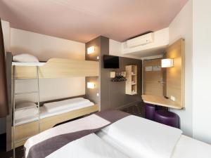 デュッセルドルフにあるB&B HOTEL Düsseldorf-Mitteの小さな客室で、ベッド1台、二段ベッドが備わります。