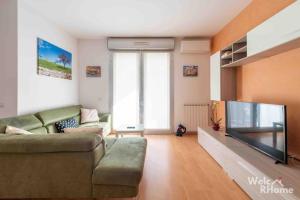 a living room with a couch and a flat screen tv at WelcRhome - 4 stops from Colosseum! in Rome